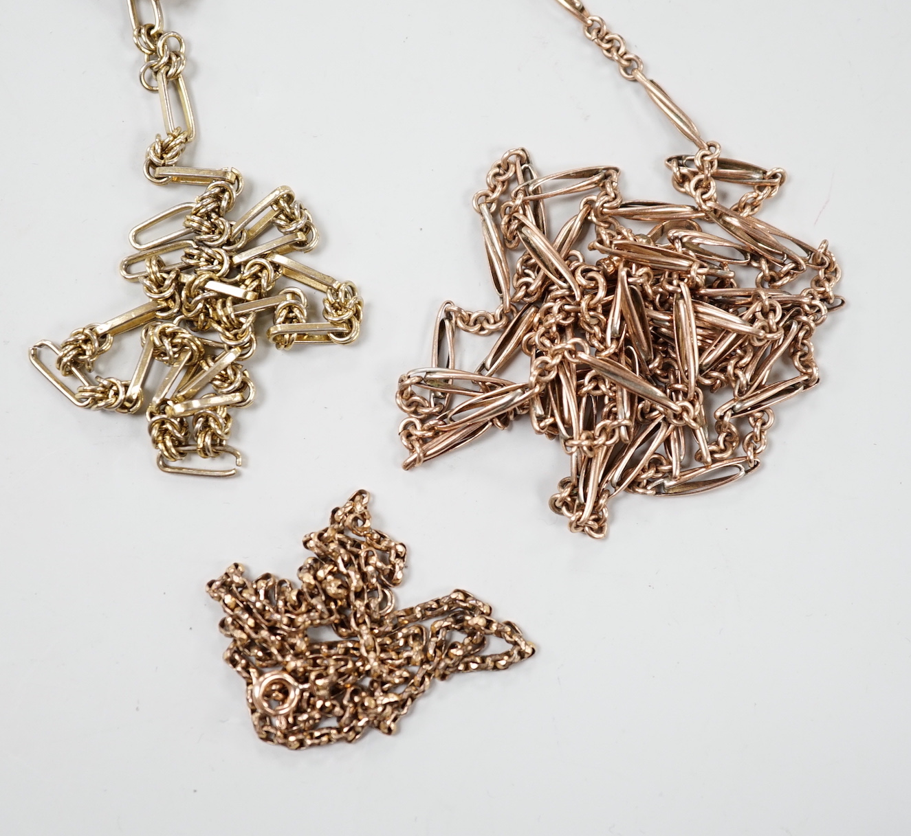 Three 19th century gilt metal chains, including a guard chain, 138cm.